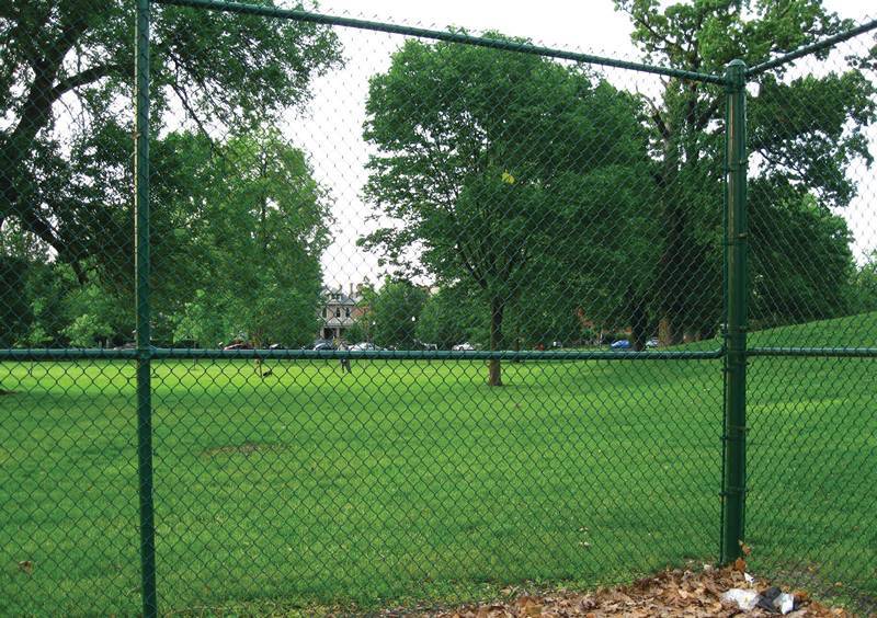 Green commercial chain link fence with middle rails for strength.