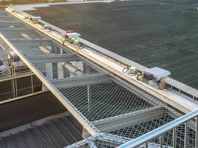 Green helipad and green chain link safety panel edge.