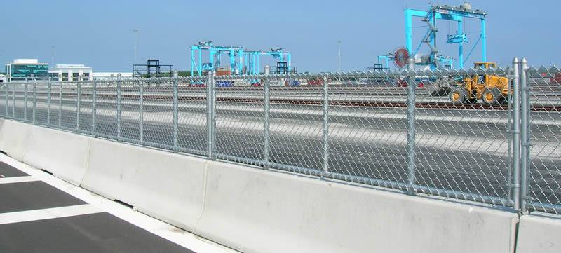 Urban highways, chain link fence in the middle of two opposite direction highways.