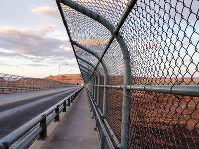 Expressway is located at barren rocky area, with chain link fence on two sides.