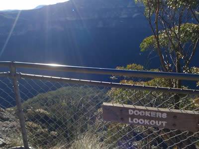 Part of lookout on the top of mountain, surrounded by chain link fence.