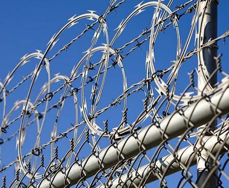 Barbed wires and razor wires are installed at the top of chain link fence for security.