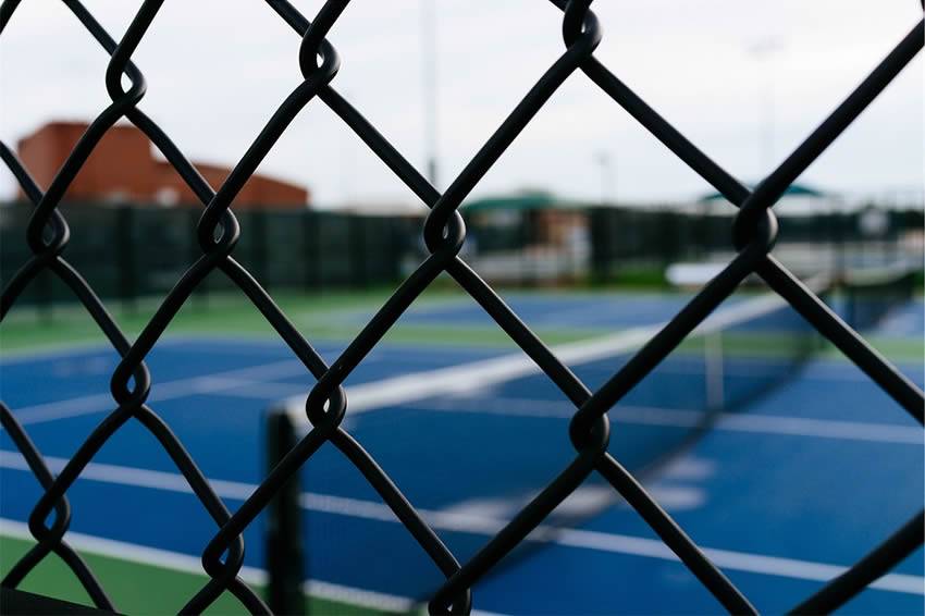 Large-diameter black chain link fence in the tennis court.
