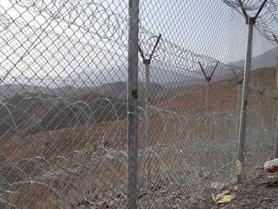 Double chain link fence with concertina barbed wire as boundary for Pakistan and Afghanistan.