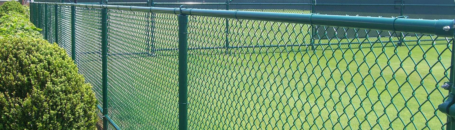 Green color chain link fences are installed on the grassland.