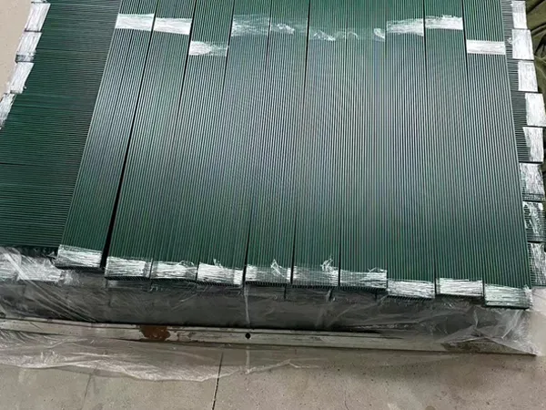 Finished chain link fence slats are placed on the ground.