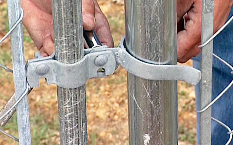 A man is installing fork latch for a swing gate.
