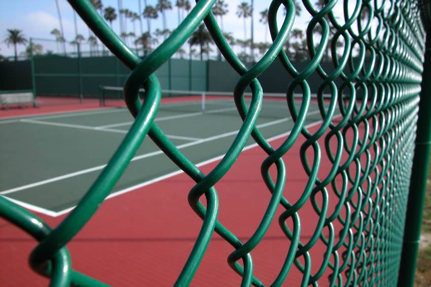 Large-diameter green chain link fence in the tennis court.