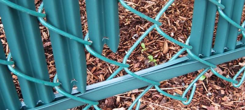 Green single wall bottom locking privacy slats installation.