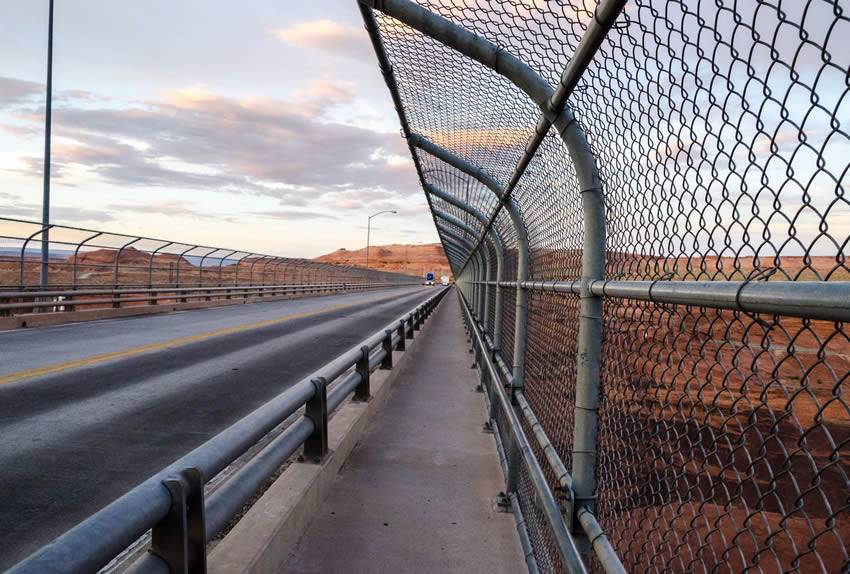 Expressway is located at barren rocky area, with chain link fence on two sides.