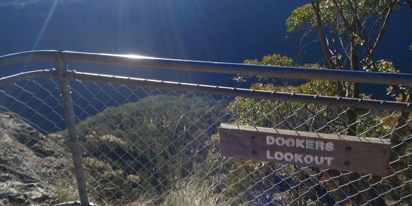 Part of lookout on the top of mountain, surrounded by chain link fence.