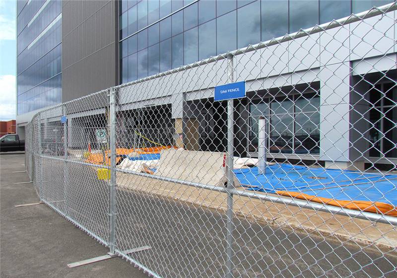 Chain link portable fencing around the construction site where in front of the office building.