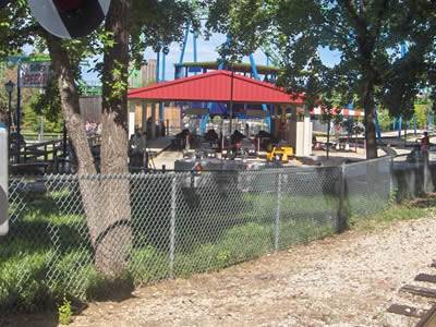 Chain link fence around trees, and as the isolation barrier between grassland and train track.