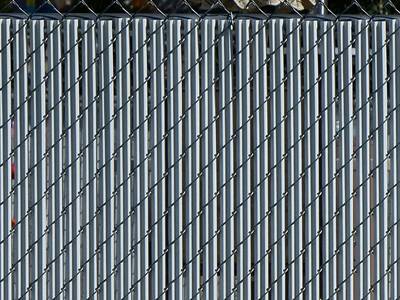 White single wall bottom locking slats for black chain link fence.